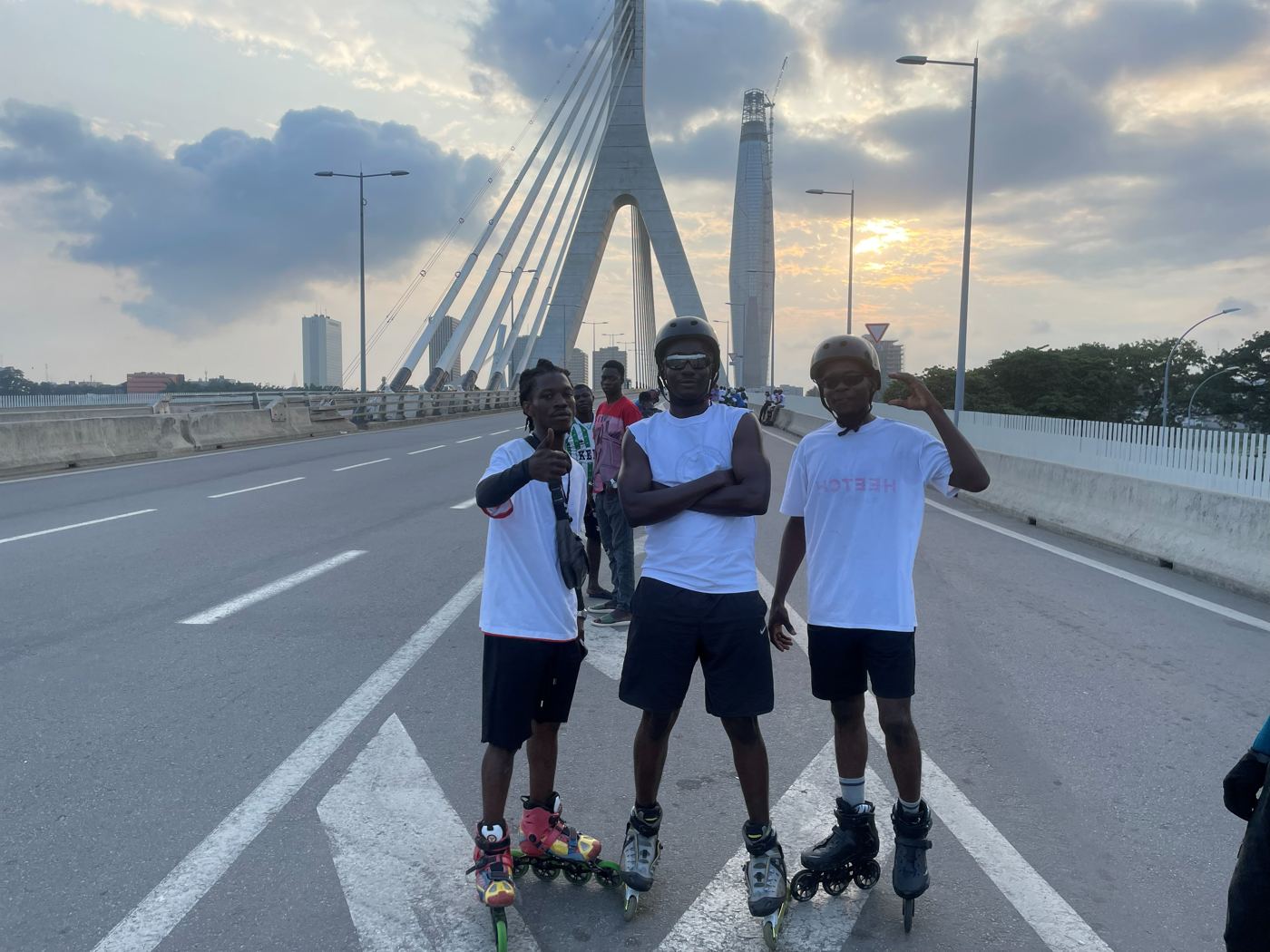 Trois patineurs en roller sur un pont à Abidjan