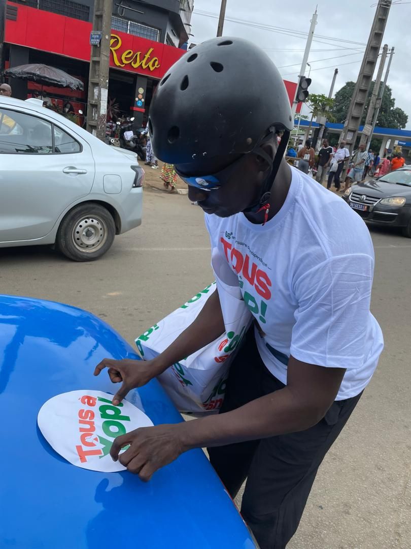 Pose d'un autocollant de campagne sur une voiture, en roller