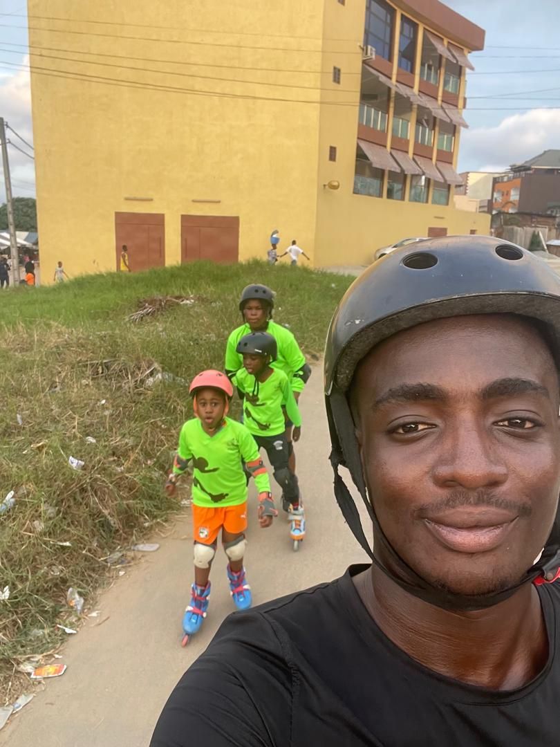 Selfie casqué pendant un cours, avec des enfants en roller derrière